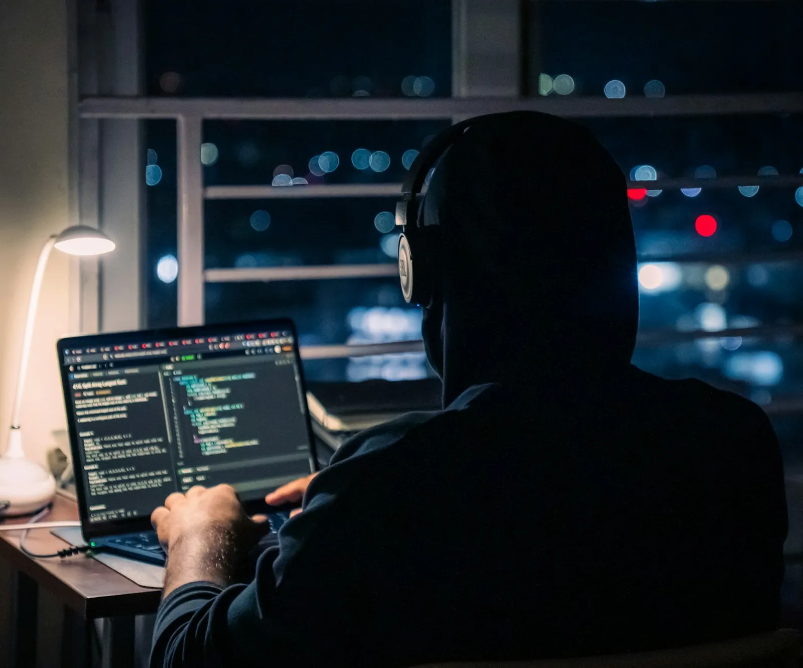 A student coding on a laptop late at night while learning AI coding tools
