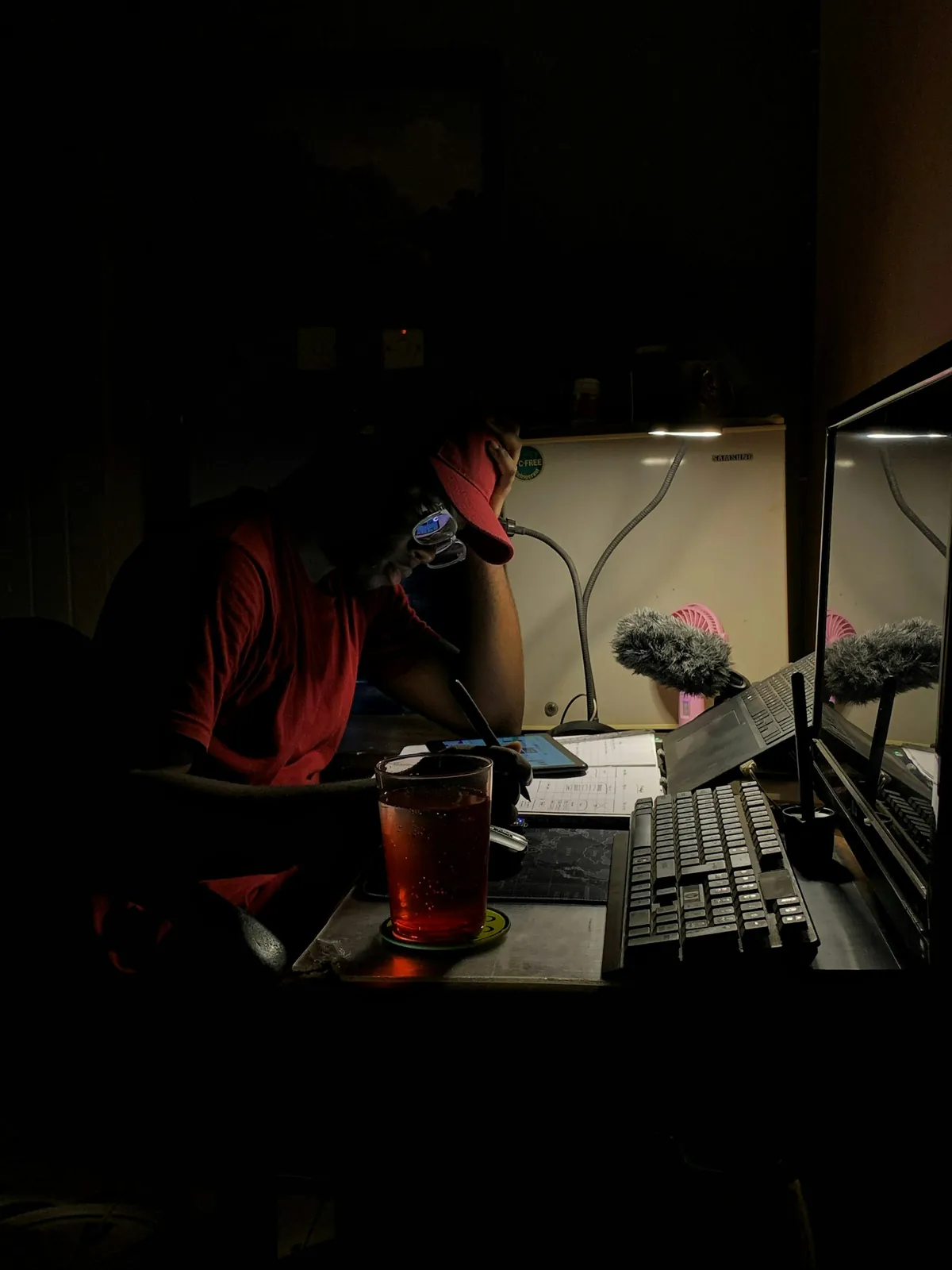 A student working on a laptop in a dark room late at night