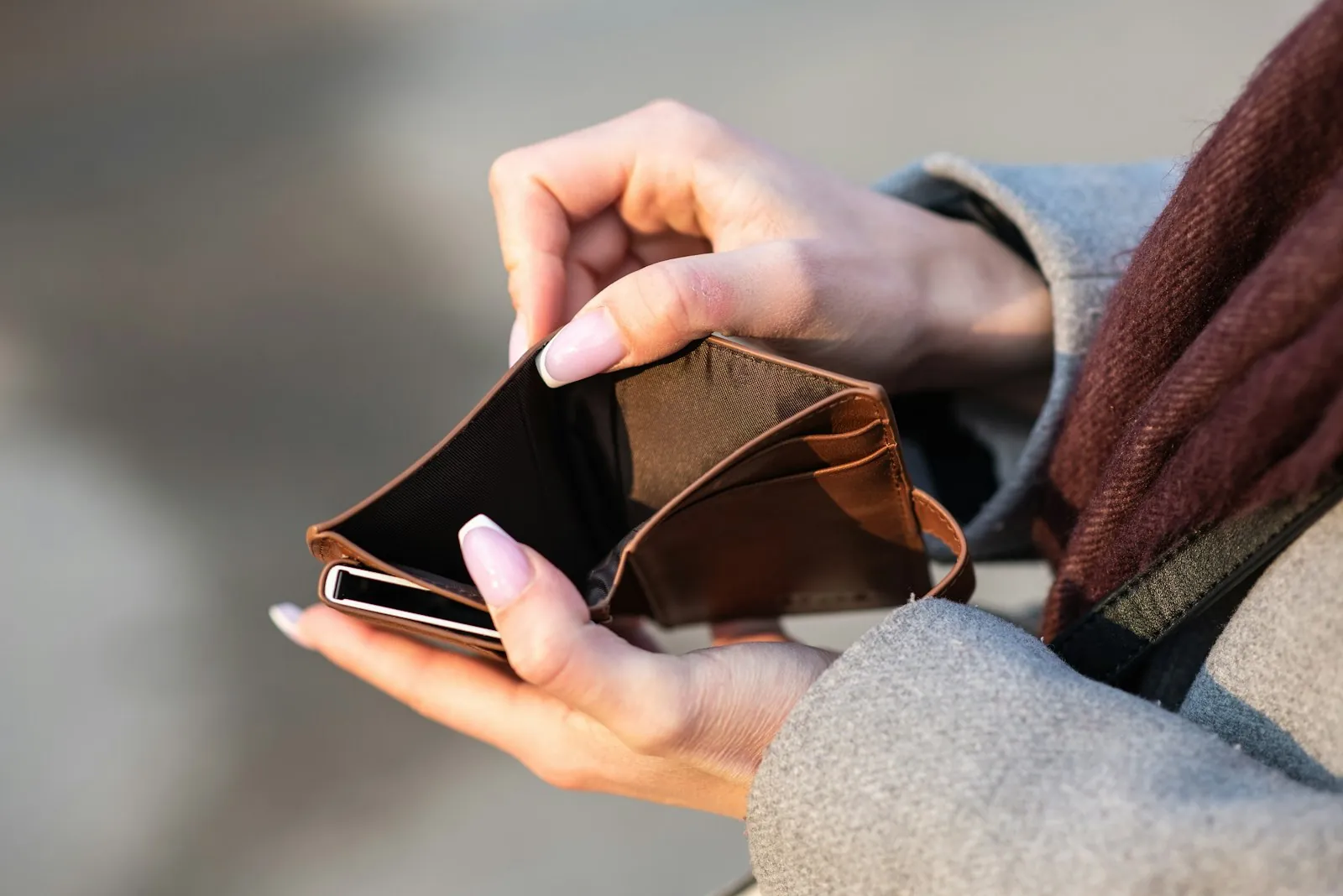 Hands opening an empty brown wallet, the feeling after paying an internship fee