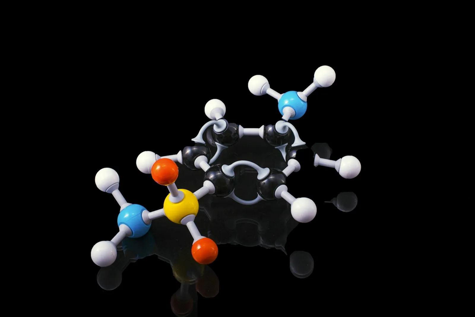 A ball-and-stick molecular model on a black surface, the kind of shape molecular docking software works with